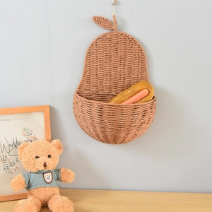 Detailed close-up of a pear-shaped woven wall basket with leaf accents and hanging loop