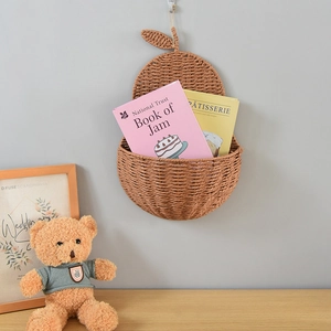 Detail of apple-shaped woven wall storage basket made of natural brown paper rope