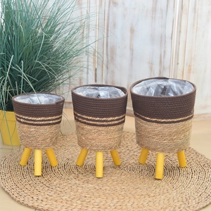 Detail view of woven plant baskets with waterproof lining and yellow wooden tripod legs