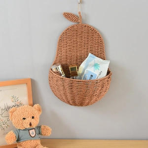 Detailed view of pear-shaped woven wall basket with decorative leaves for home storage