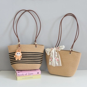 Detail of woven straw tote bags featuring striped patterns and lace floral bow accents