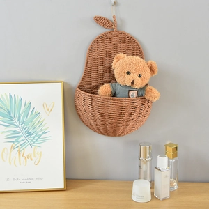 Detail view of pear-shaped woven hanging basket with a plush bear in home decor
