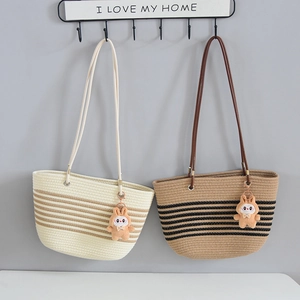 Detail view of woven tote bags with striped patterns and cute rabbit plush charms