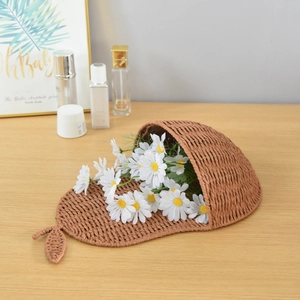 Handwoven pear-shaped storage basket in brown paper rope with small daisy flower decor
