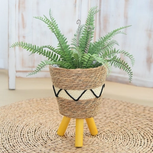 Nordic woven plant stand with yellow wooden legs and decorative seagrass basket