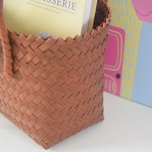 Close-up of dark brown hand-woven basket with detailed diagonal texture and handle
