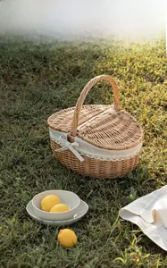 Dettaglio di un cesto da picnic in vimini fatto a mano con pizzo su prato soleggiato