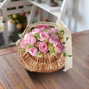 Detail of hand-woven wicker flower basket with silk ribbons and pink roses decor