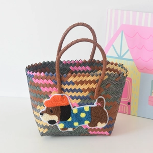 Close-up of a woven tote bag with a 3D puppy embroidery patch and leather handles