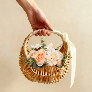 Detail of woven handheld flower basket with silk ribbons and delicate artificial roses