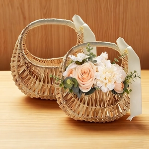 Detail view of woven wicker baskets with cream ribbons and floral arrangements in two sizes