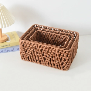 Detailed macro view of three nested brown woven rectangular baskets on a white desk