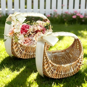 Set of two woven wicker baskets with white satin bows on sunny green lawn garden