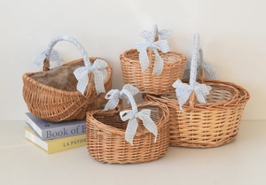 Detailed set of four natural wicker picnic baskets with blue checkered bow ribbon accents