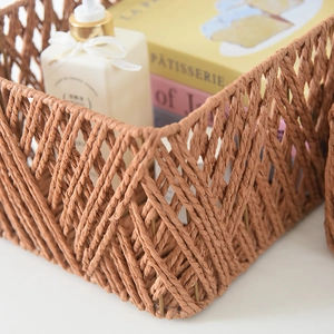 Detail of woven faux rattan storage basket showing intricate brown fiber patterns and metal frame