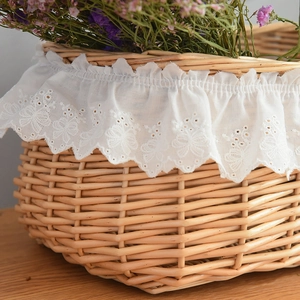 Macro detail of hand-woven wicker picnic basket with elegant white lace lining edge