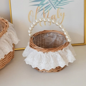 Detailed close-up of a woven flower basket with lace embroidery and pearl handles