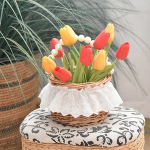 Detail of woven wicker basket with white lace trim, pearl handle and faux tulips