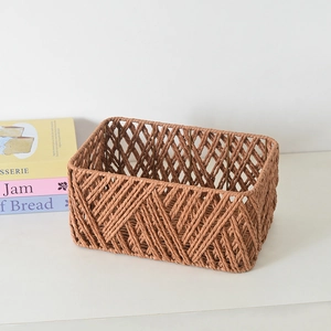 Detail of terracotta woven storage basket showing diamond weave and metal frame
