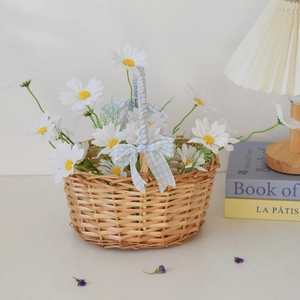 Detail of woven picnic basket with blue white checkered bow and artificial daisies