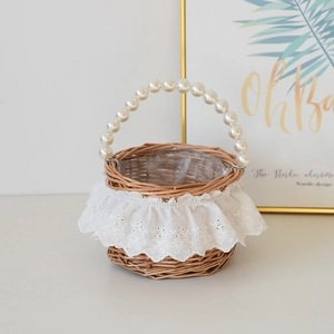 Detail of hand-woven wicker picnic basket with pearl handle and white lace trim edge