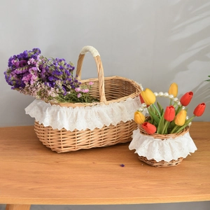 Close-up of woven picnic baskets with decorative white lace edges and pearl bead handle