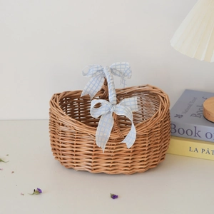 Detailed view of hand-woven wicker picnic basket with blue checkered bow decorations