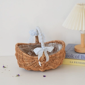 Detail view of a handwoven wicker basket with blue gingham bows and waterproof liner