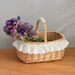 Detail of hand-woven wicker basket with white lace trim and purple dried flowers