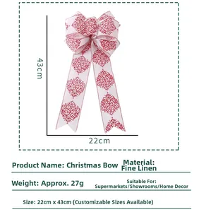 Detailed view of white linen Christmas bow with red Damask pattern and long streamers