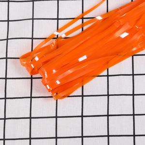 Close-up of shiny orange foil fringe curtain for Halloween and party background decor
