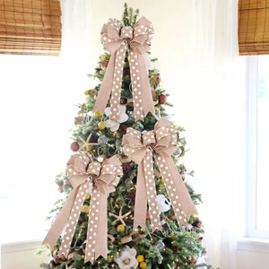 Three linen Christmas bows with white polka dots on a green festive tree branch