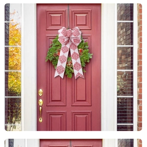 Detail of large white Christmas bow with red scroll pattern on green wreath and door