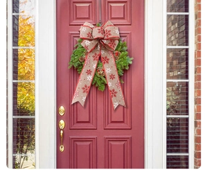 Detail of Christmas burlap bow with snowflake pattern on a festive green door wreath