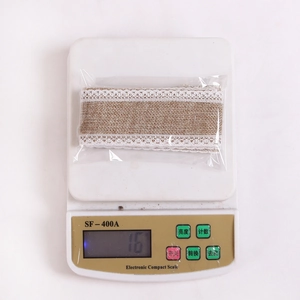 Close-up of linen burlap ribbon with white lace on an electronic scale weighing 16g
