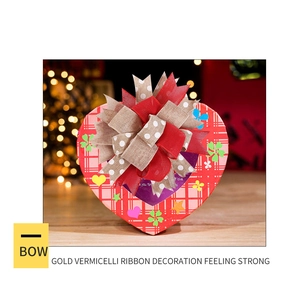 Close-up of a layered red and linen Christmas bow placed on a decorative gift box