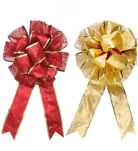 Detailed close-up of large red and gold Christmas bows with shimmering glitter and gold trim