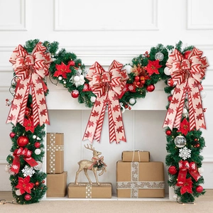 Double-layered Christmas bow decoration with red maple leaves on a white fireplace