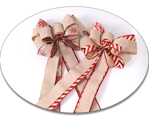 Macro detail of rustic linen Christmas tree bows with snowflake patterns and red ribbons