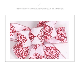Detailopname van rustieke kerststrik met rode bloemenprint op wit getextureerd canvas