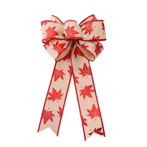 Christmas bow decoration with autumn maple leaf pattern on linen-style fabric