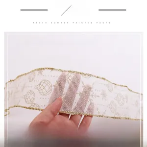 Macro detail of transparent Christmas ribbon with gold edges and glitter print patterns