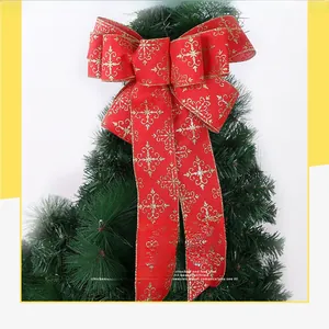 Macro shot of a red Christmas bow with golden snowflake patterns and metallic edges