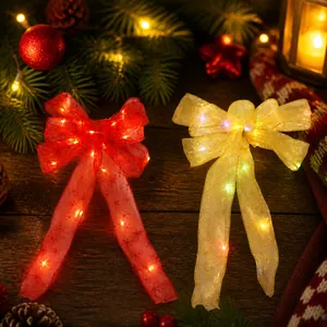 Detail of red and gold LED Christmas ribbon bows with snowflake prints and battery packs