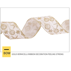 Close-up of white linen ribbon with gold glitter snowflakes and Christmas ornaments