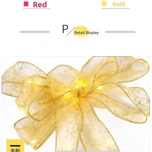 Detail of gold mesh Christmas ribbon bow with LED lights and snowflake patterns