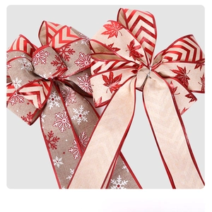 Macro detail of Christmas bows featuring snowflake and maple leaf textures with red piping