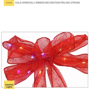 Macro detail of red ribbon bow with snowflake print and built-in colorful LED lights