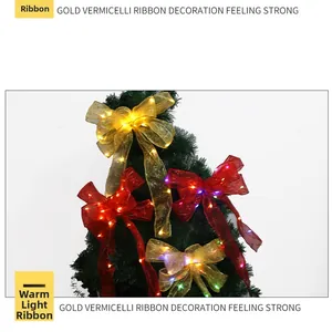 Close-up of golden and red LED Christmas ribbons on a tree branch with warm lights