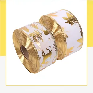 Detail of Christmas ribbon with gold reindeer and tree patterns for DIY gift wrapping